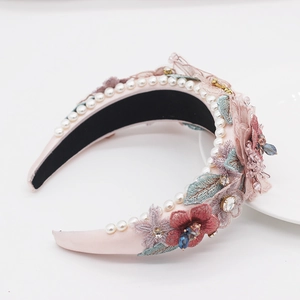 Close-up of pink baroque headband with intricate floral embroidery and pearl trim detail