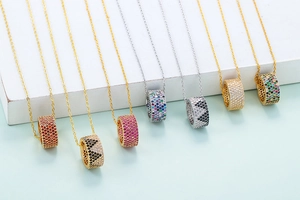 Close-up of minimalist cylindrical cylinder pendants with pavé crystals in various colors