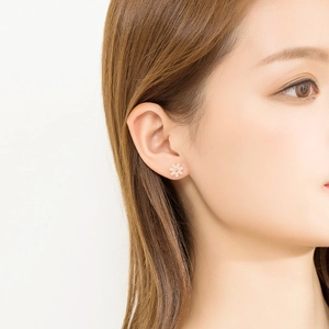 Elegant rose gold daisy flower stud earrings shown on model for a minimalist look