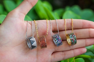 Close-up of elegant gold and silver cylinder necklaces with colorful inlaid crystals