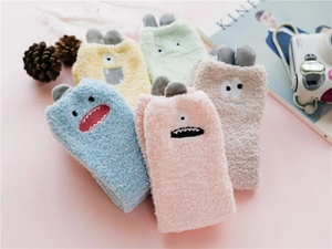 Five pairs of fluffy coral fleece socks with cute cartoon monster ears and colorful pastel tones