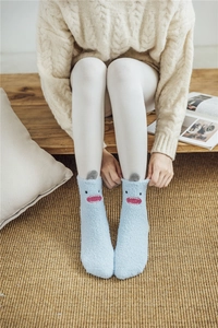 Detail of blue coral fleece mid-calf socks featuring cute cartoon monster design for home