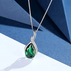 Detail of teardrop pendant with pear-shaped green stone and shimmering crystals