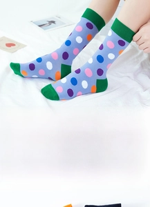 Close-up of colorful polka dot cotton crew socks with vibrant green toe and heel detail