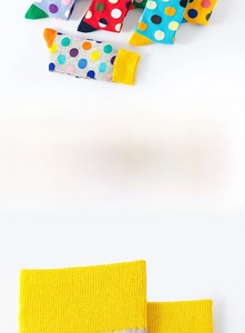 Detail of colorful polka dot cotton socks with ribbed yellow cuffs for men and women