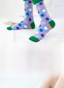Detailed close-up of purple polka dot cotton crew socks with green contrast toe and heel