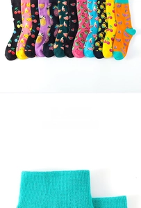 Detail der Rippbündchen und bunten Fruchtmuster auf Baumwollsocken inklusive Kirschen