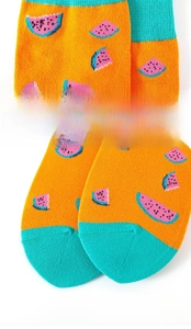 Detail von elastischem Bund und Spitze an orangefarbenen Baumwollsocken mit Wassermelone