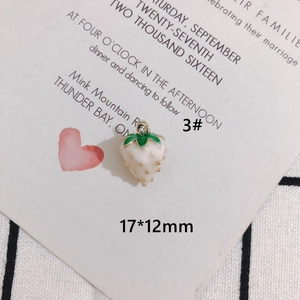 Macro shot of 17x12mm cream strawberry charm with green leaves for DIY jewelry making