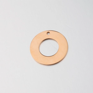Macro view of a polished rose gold circular hollow metal pendant for DIY jewelry making