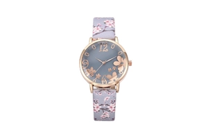 Detail of rose gold watch face with grey floral strap and artistic number 12 dial