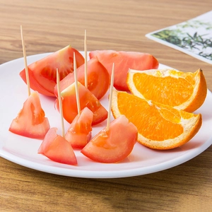 Natural bamboo toothpicks set inserted into fresh fruits on a white plate