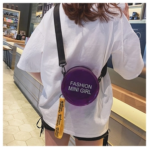 Detail of round purple laser jelly bag with FASHION MINI GIRL logo and yellow strap