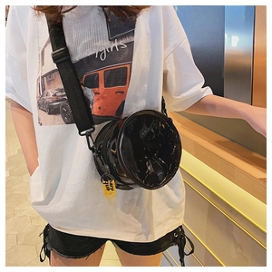 Macro shot of circular PVC crossbody bag with yellow strap and fashion mini girl text