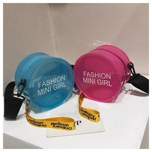 Detail of round semi-transparent PVC shoulder bags in blue and pink with slogan straps