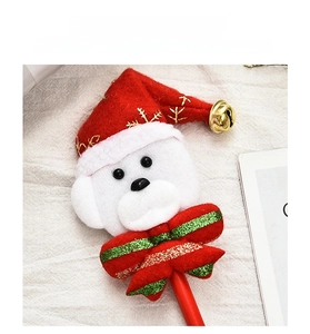 Détail d'un stylo de Noël avec un petit ours en peluche portant un bonnet de Père Noël