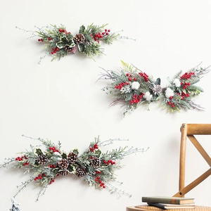 Christmas garland wall decor with natural pine cones berries and cotton on white wall