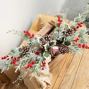 Christmas garland with red berries, snowy pine cones and needles on a rustic wooden box