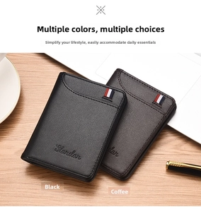 Detailed view of slim black and coffee wallets with tricolor ribbon on wooden desk