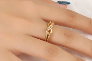 Close-up of golden infinity ring with pavé rhinestones on a model's finger