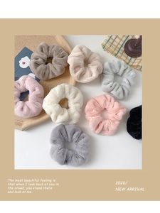Detail showing eight soft plush hair scrunchies in various neutral colors and textures