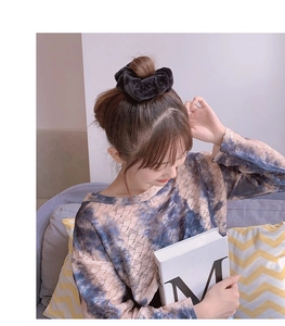 Close-up of black plush scrunchie worn on hair for a cozy autumn fashion style