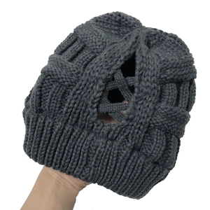 Detailed macro view of dark grey chunky knit beanie with unique crisscross pattern weave