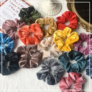Colorful velvet scrunchies set on vintage decor background showing soft texture