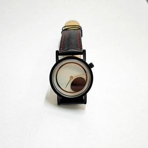 Detail of minimalist black leather watch strap with contrast red stitching and white dial