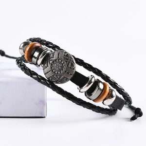 Retro multi-layer leather bracelet with metal shield charm and beads on white marble stand