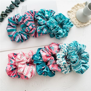 Set of 7 velvet Christmas hair scrunchies with pink and teal holiday patterns