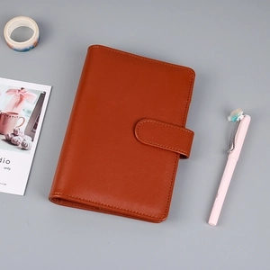 Detalle de la funda del cuaderno de cuero marrón con bordes cosidos y cierre de hebilla