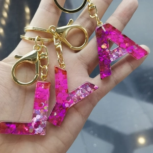 Resin initial alphabet keychain in pink purple glitter finish with gold hardware