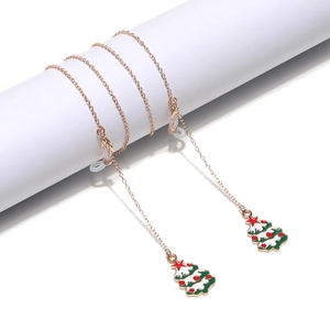 Rose gold Christmas eyewear chain with enamel tree pendant on white display stands
