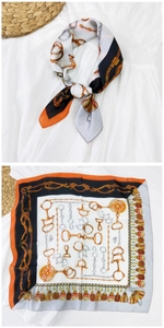 Dettaglio di un foulard quadrato in seta con stampa equestre, morsi e nappe eleganti