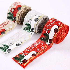 Close-up of three rolls of burlap Christmas ribbons with vintage truck and tree patterns
