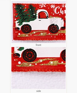 Detail of red Christmas ribbon featuring white truck carrying tree with gold glitter accents