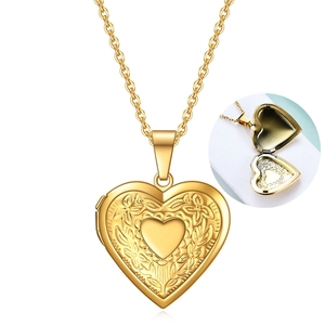 Detail of a golden heart locket necklace with floral engraving and inner photo compartment