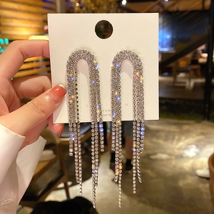 Close-up of sparkling silver tassel earrings with crystal rhinestones on a display card