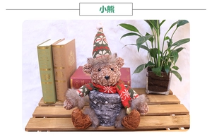 Close-up of a festive plush Christmas bear wearing a knit hat and scarf in a tray