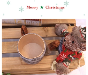 Macro detail of Christmas reindeer kraft gift box with festive knit teddy bear decoration