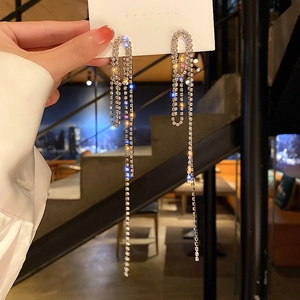 Macro shot of silver multi-row rhinestone tassel earrings on a white display card