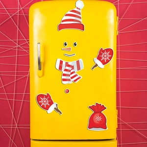 Detail of Christmas snowman magnetic stickers applied to a yellow vintage refrigerator