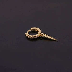 Détail de la boucle d'oreille dorée avec zircons clairs et pendentif en forme de pointe