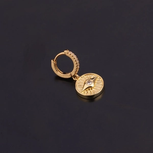 Détail macro de boucles d'oreilles cœur boussole plaquées or avec zircons brillants