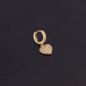 Détail d'une boucle d'oreille cœur dorée avec oxydes de zirconium sur fond noir