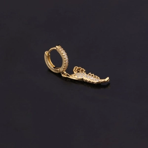 Détail de la boucle d'oreille dorée avec pendentif scorpion et zircons brillants