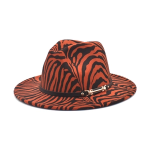 Vue détaillée du chapeau fedora à motif zèbre avec ruban en cuir noir et boucle dorée