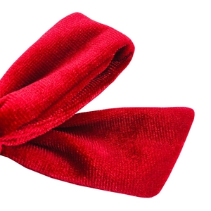 Macro shot of red velvet ribbon texture and fine stitching detail on handmade bow