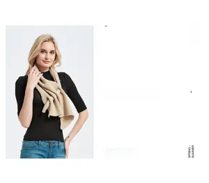 Detailed knit texture of beige hollow-out triangular scarf with soft yarn material